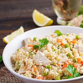 A serving of couscous topped with peas and chicken