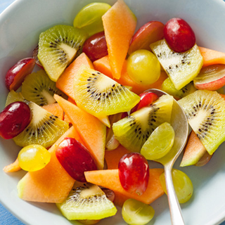 Bowl of sliced grapes, melon and kiwi