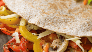 Cheats' pizza with cooked veg, including mushrooms, peppers and cheese in a folded tortilla.