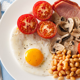 Cooked breakfast comprised egg, tomatoes, mushrooms, bacon, sausage and beans