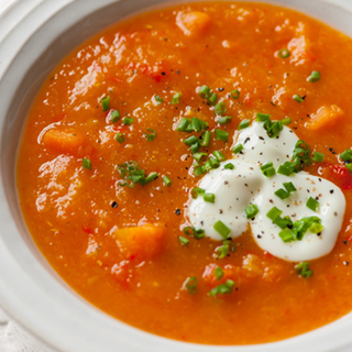 A bowl of thick, carrot, pepper and red lentil soup