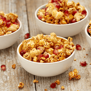 A bowl of piri-piri seasoned popcorn with pomegranate seeds