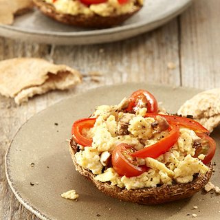 Scrambled eggs and sliced peppers on a large grilled mushroom cap