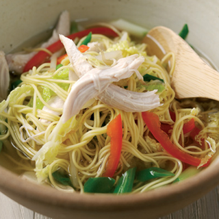 Bowl of chicken noodle soup with red and green peppers