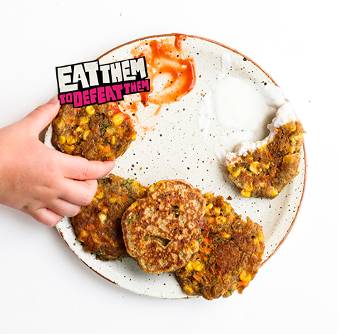 4 golden sweet potato and sweetcorn fritters on a plate with mint yoghurt dip