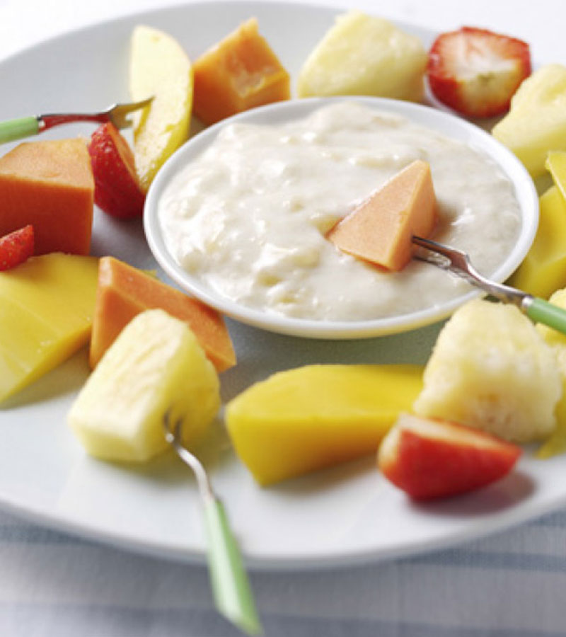 Various pieces of fruit sliced up and served with a banana dip